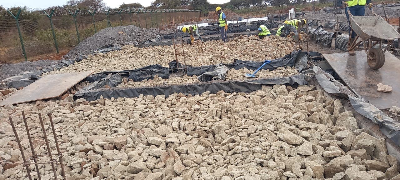 Hardcore rubble being packed into foundation trenches