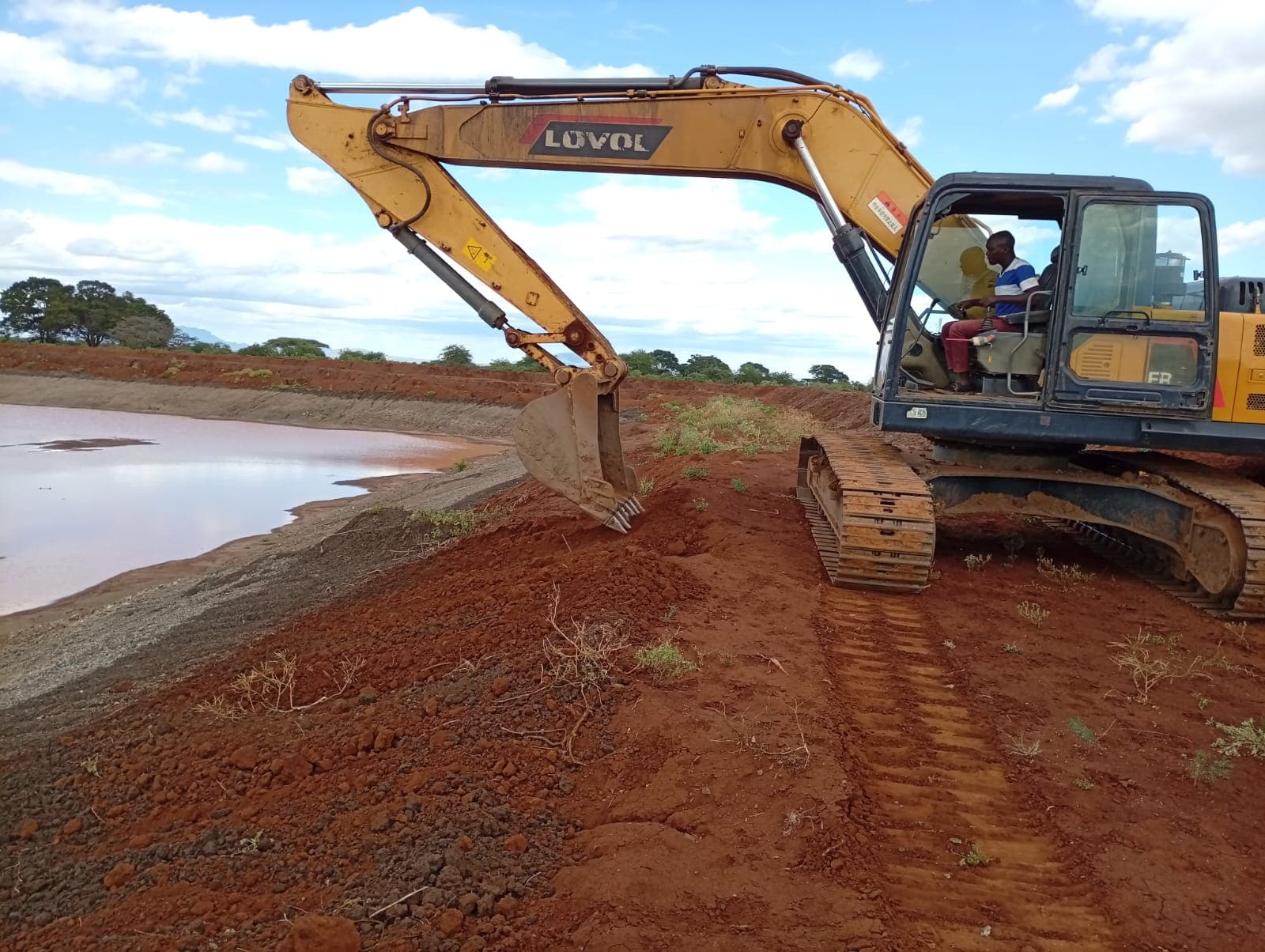 Lovol excavator shaping the bank of a water dam