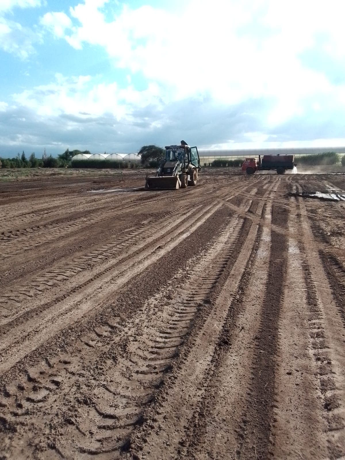 Nelber backhoe loader grading a site access road