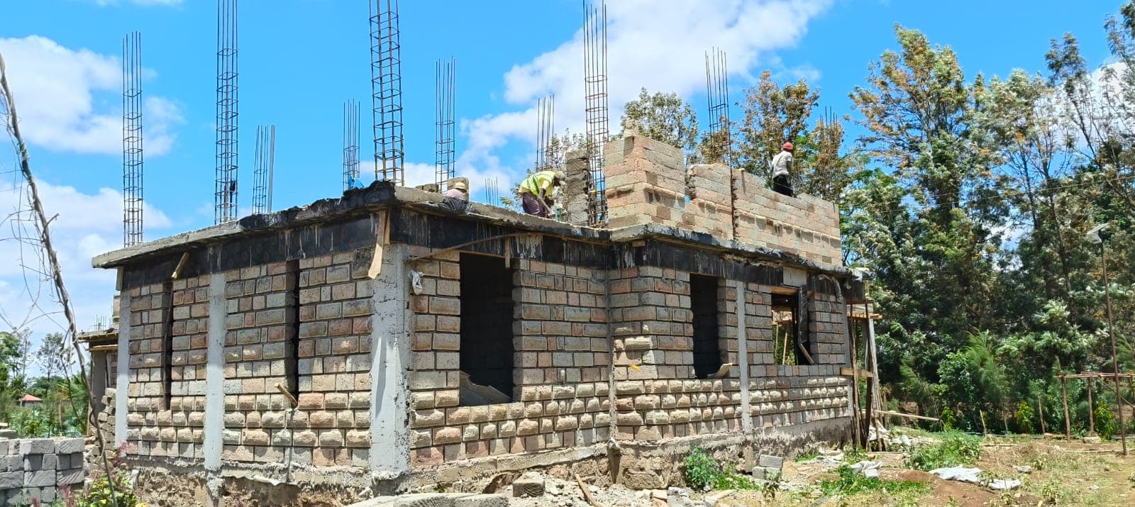 House under construction with column starter bars awaiting the roof slab